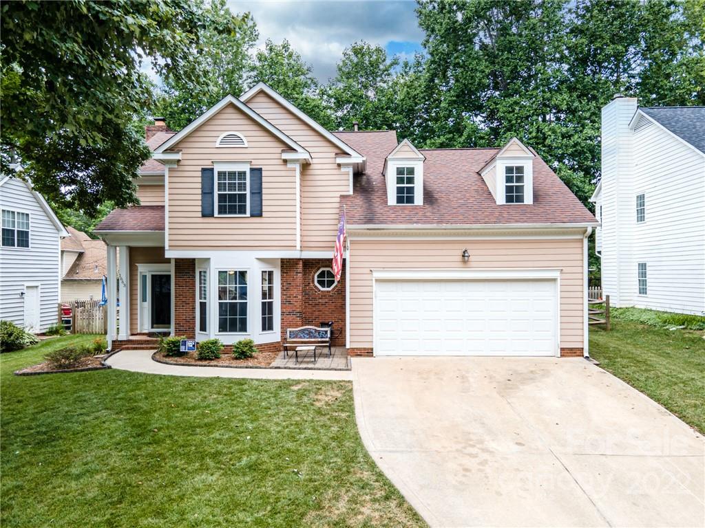 a view of a white house with a small yard and plants