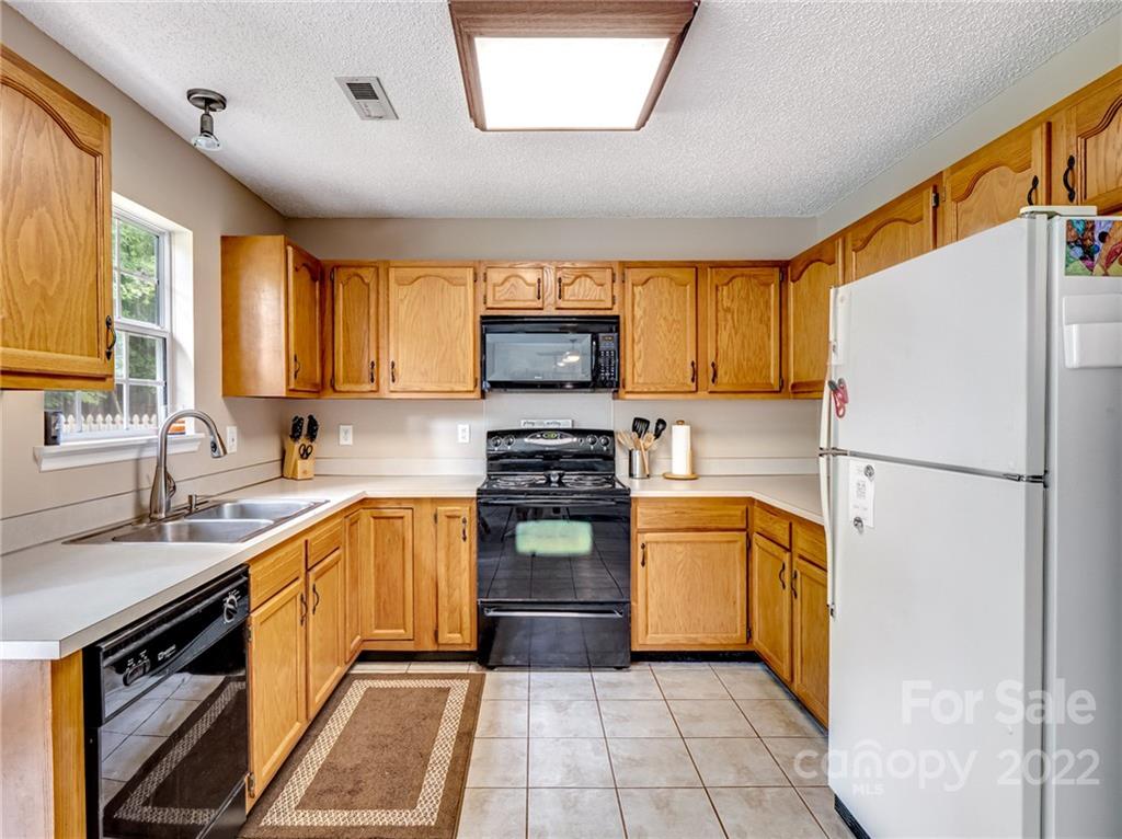 1663 Heather Glen Road Kannapolis, NC 28081 - Photo 12 of 30 a kitchen with a refrigerator sink and wooden cabinets