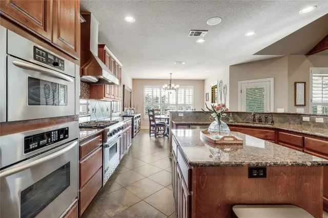 a kitchen with stainless steel appliances granite countertop a stove and a sink