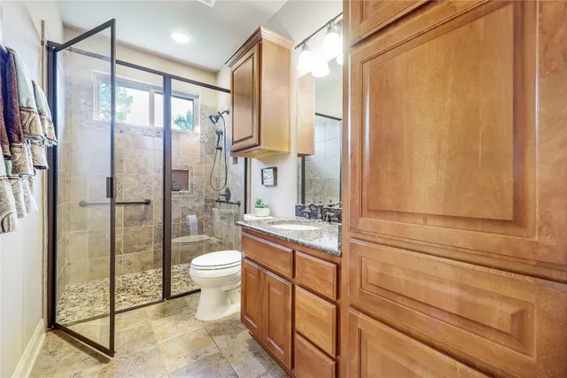 a bathroom with a granite countertop sink toilet and shower