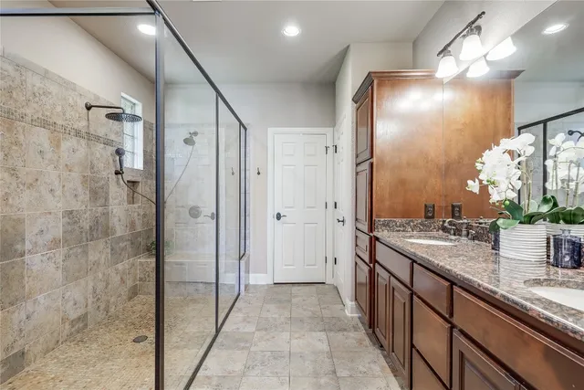 a bathroom with a double vanity sink mirror and shower