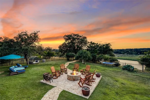 a view of a swimming pool and lounge chairs in back yard of the house