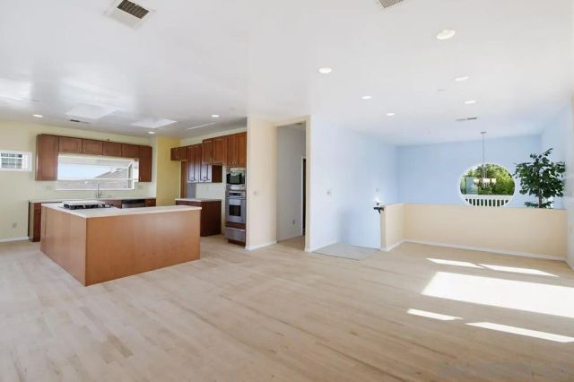 a view of kitchen with kitchen island microwave and cabinets