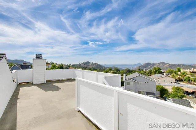 a view of a terrace with yard and mountain view in back