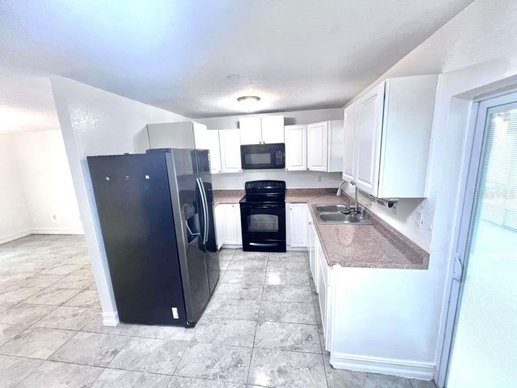 3409 Vorden Street New Port Richey, FL 34655 - Photo 13 of 41 a view of a kitchen with refrigerator and windows