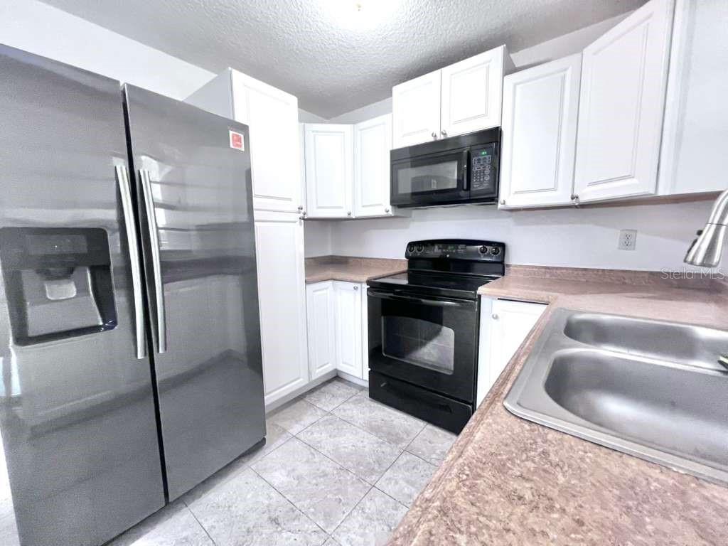 3409 Vorden Street New Port Richey, FL 34655 - Photo 17 of 41 a kitchen with granite countertop a refrigerator stove and microwave