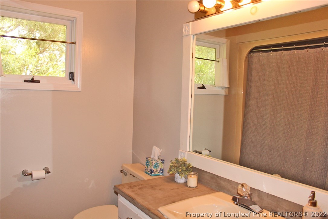 679 Cedar Point Vass, NC 28394 - Photo 12 of 18 a bathroom with a granite countertop sink toilet and mirror