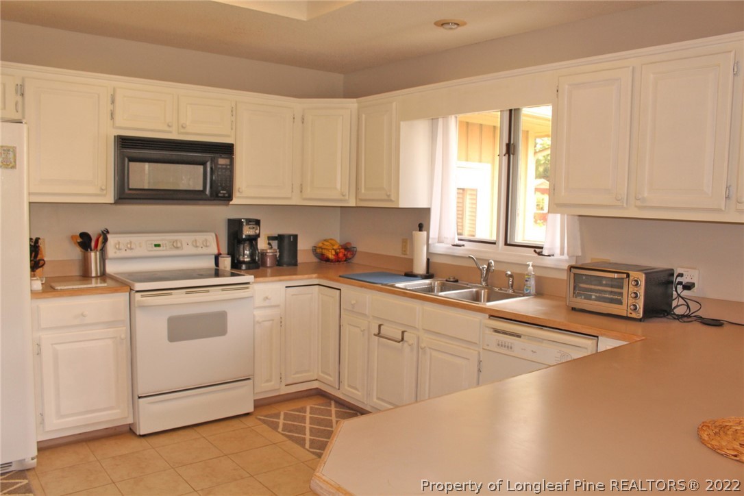 679 Cedar Point Vass, NC 28394 - Photo 3 of 18 a kitchen with stainless steel appliances granite countertop a sink dishwasher stove top oven and cabinets with wooden floor