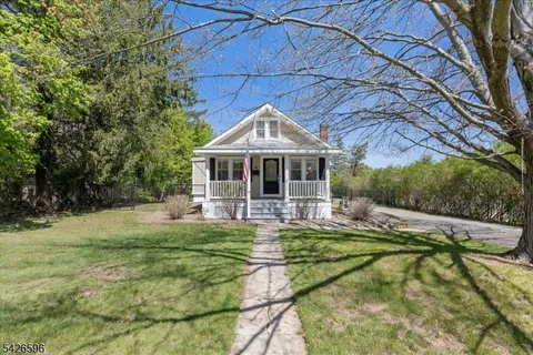 a front view of a house with swimming pool and porch with furniture
