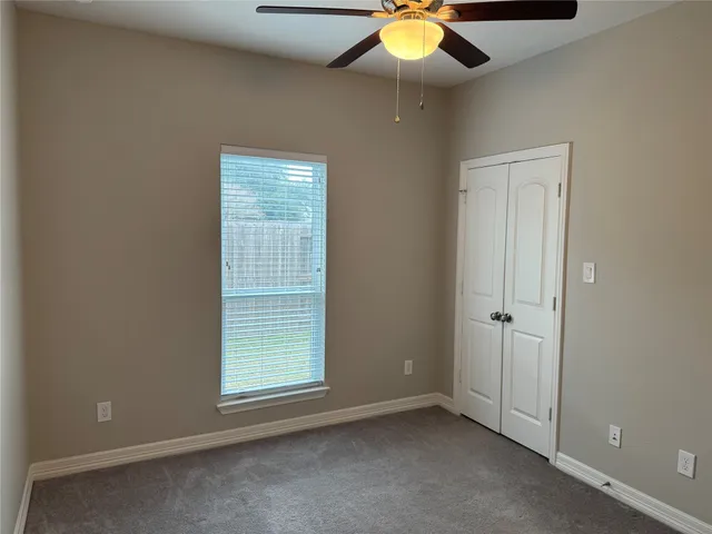 an empty room with a ceiling fan and painted walls