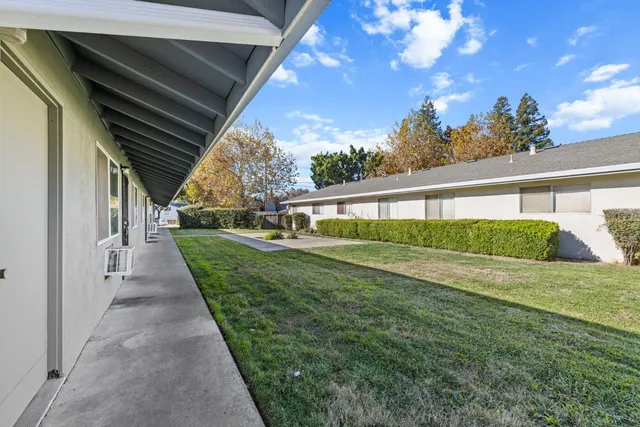 an empty room with wooden floor cabinet and windows