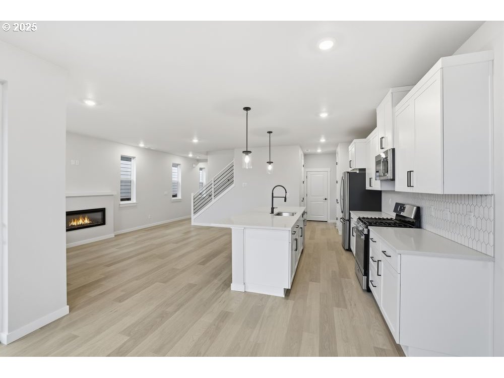 3736 Southwest 38th Street Gresham, OR 97080 - Photo 6 of 15 a view of a kitchen with kitchen island a sink stainless steel appliances and a counter top