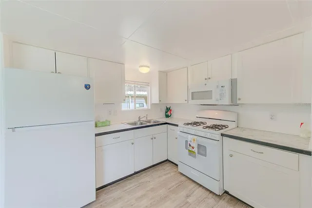 a kitchen with white cabinets and white appliances