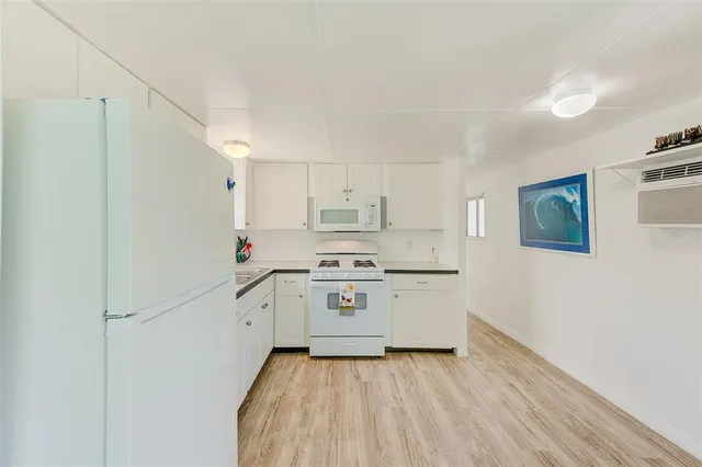 a kitchen with stainless steel appliances a stove and white cabinets