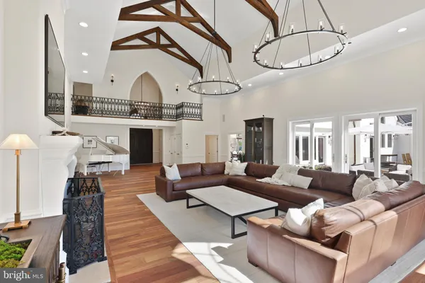 a living room with furniture a fireplace and chandelier