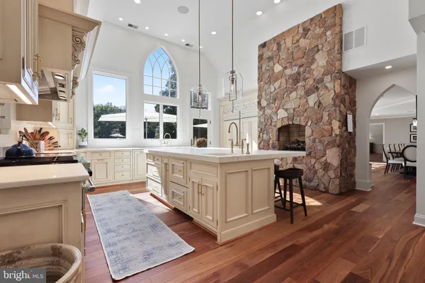 a large kitchen with stainless steel appliances granite countertop a lot of cabinets and wooden floor