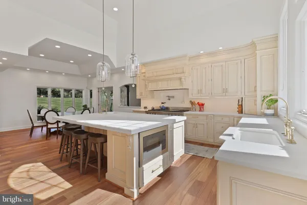 a open kitchen with stainless steel appliances granite countertop a stove and a dining table chairs
