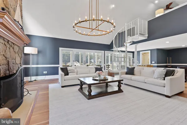 a living room with furniture a fireplace and a chandelier