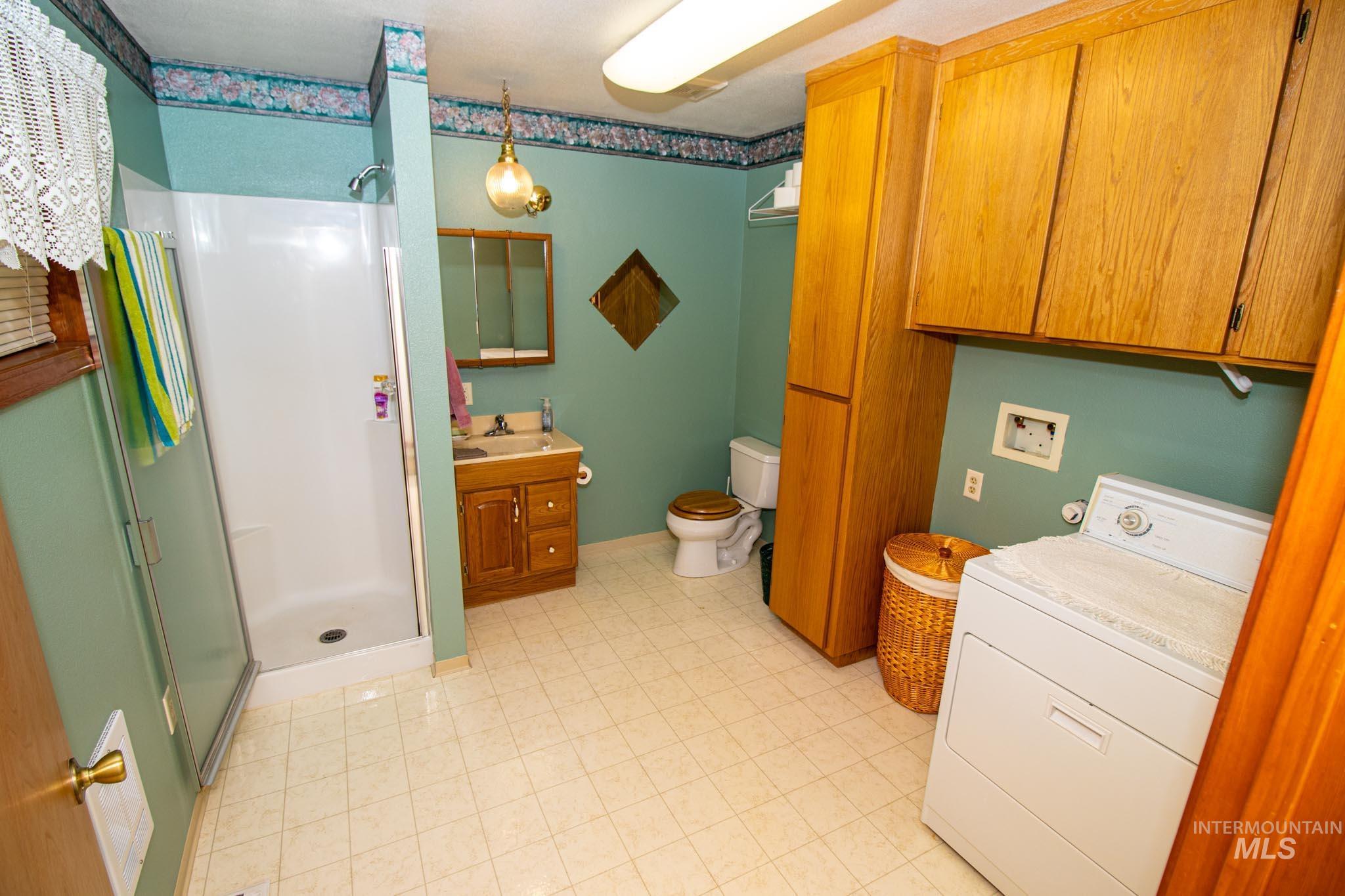 20888 Upper Fords Creek Road Weippe, ID 83553 - Photo 15 of 50 Full bathroom featuring vanity, washer / clothes dryer, and a shower stall
