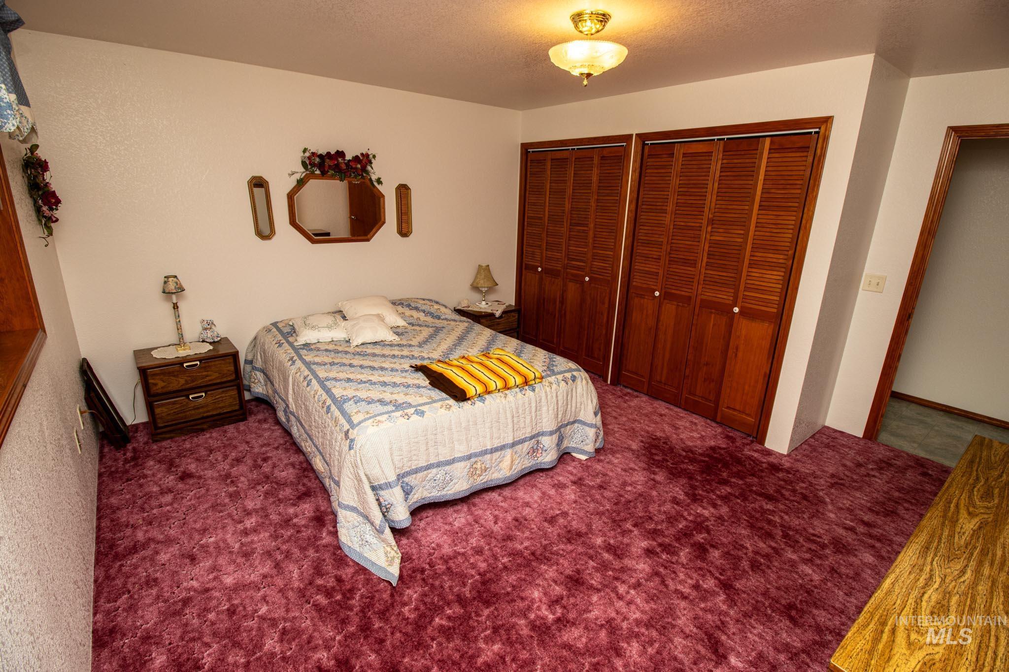 20888 Upper Fords Creek Road Weippe, ID 83553 - Photo 16 of 50 Carpeted bedroom featuring two closets and a textured ceiling