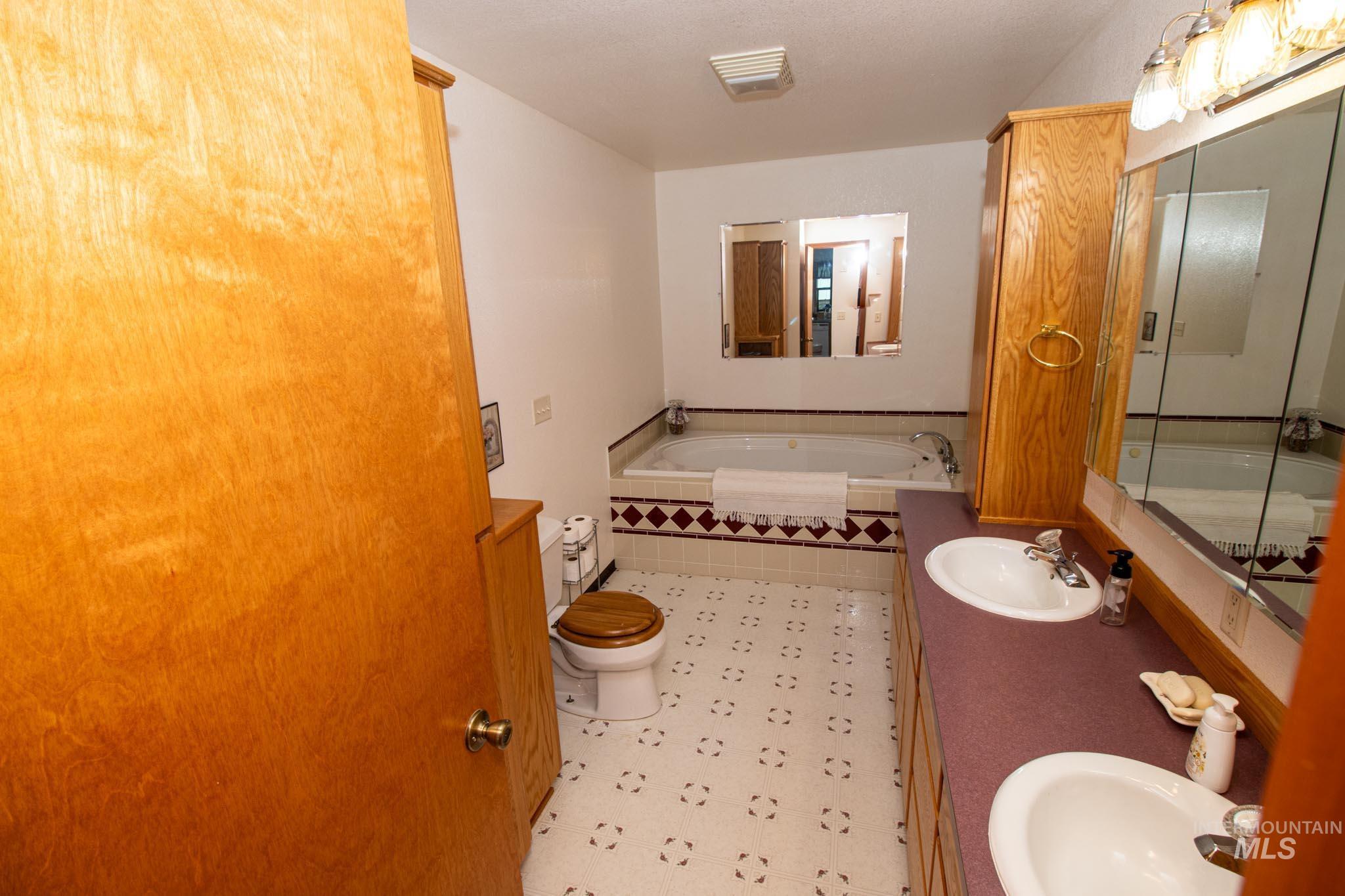 20888 Upper Fords Creek Road Weippe, ID 83553 - Photo 18 of 50 Full bath featuring double vanity, a bath, and light flooring