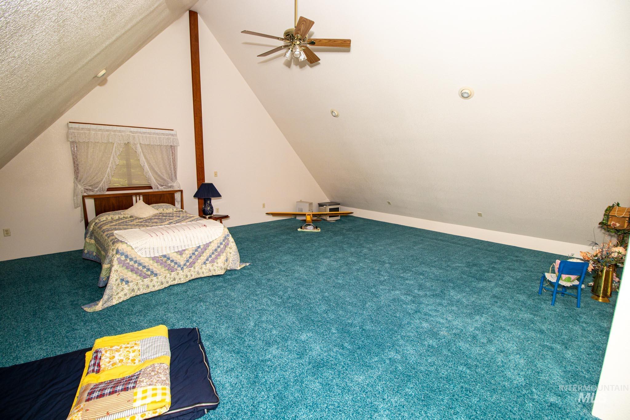 20888 Upper Fords Creek Road Weippe, ID 83553 - Photo 20 of 50 Carpeted bedroom featuring vaulted ceiling and ceiling fan
