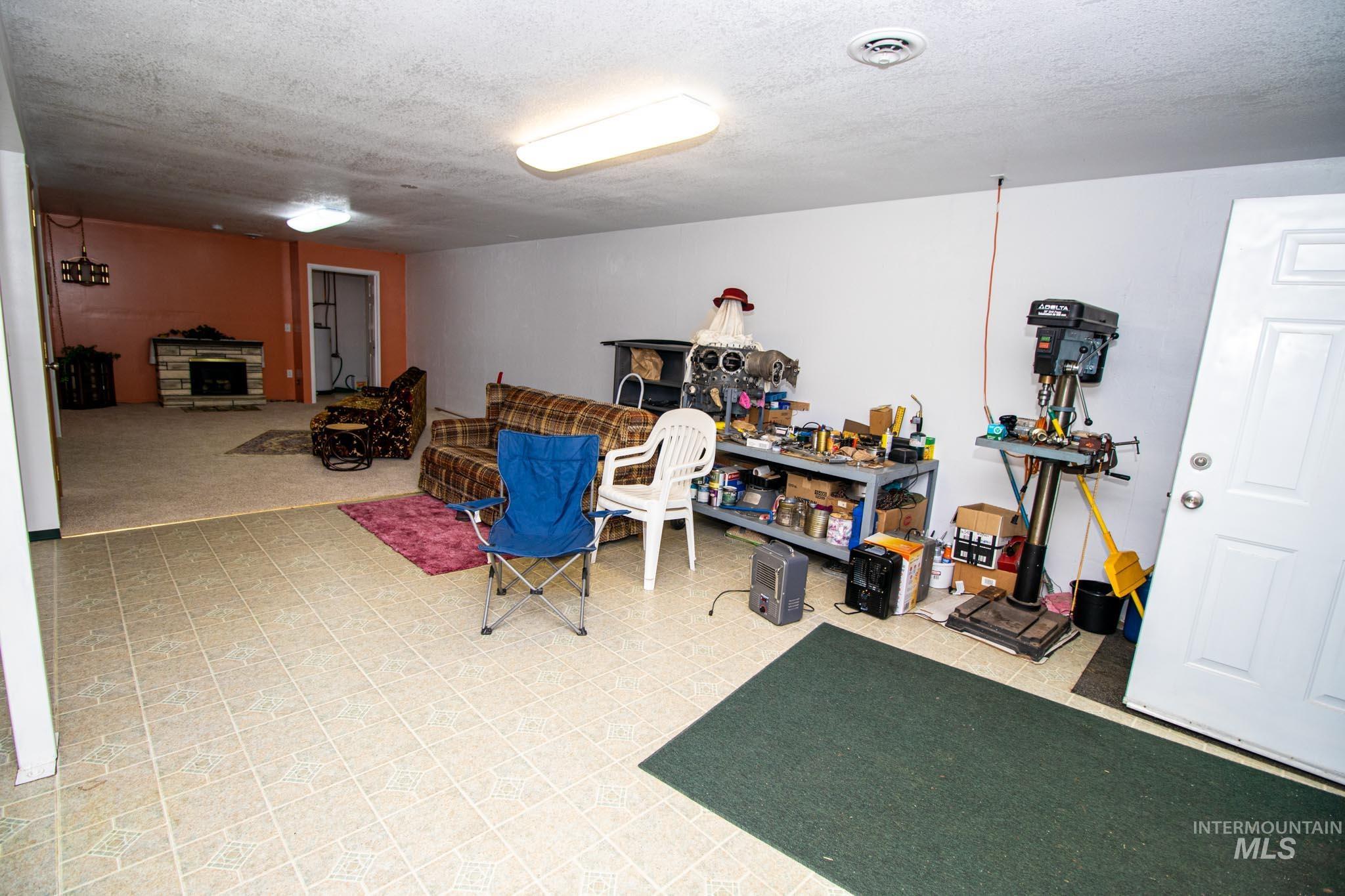 20888 Upper Fords Creek Road Weippe, ID 83553 - Photo 21 of 50 Recreation room featuring light flooring, a textured ceiling, and a fireplace