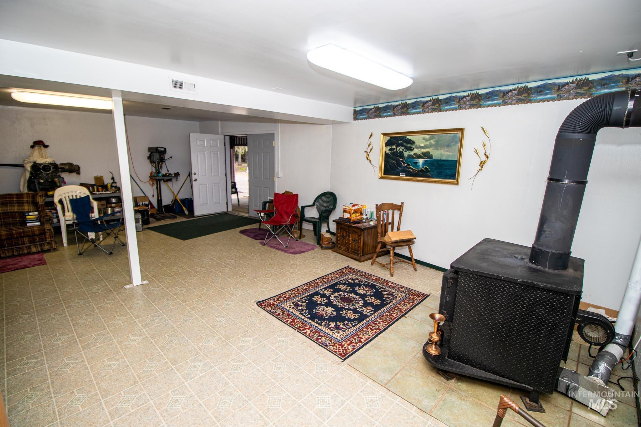 20888 Upper Fords Creek Road Weippe, ID 83553 - Photo 22 of 50 Finished basement featuring a wood stove and light floors