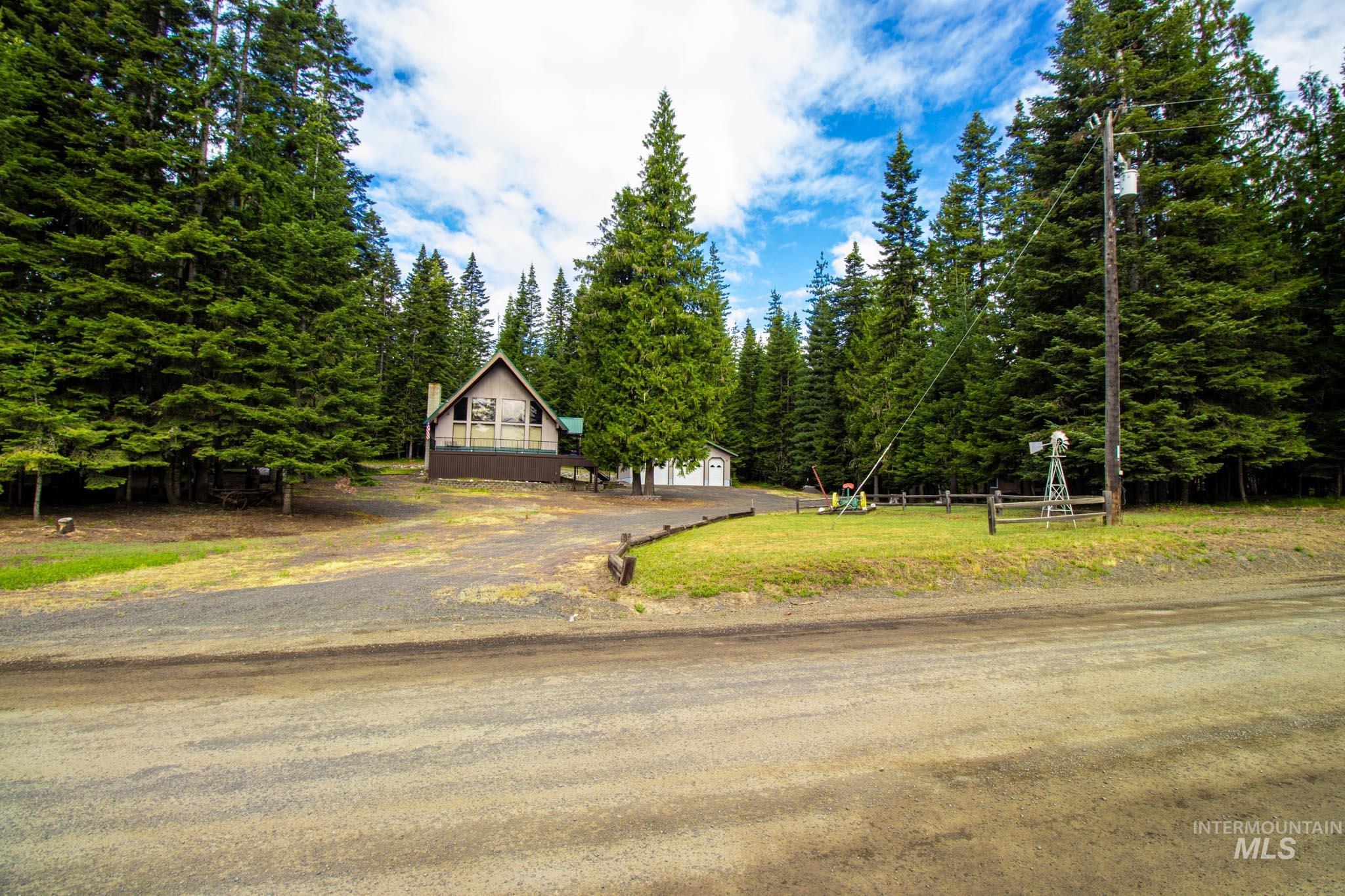 20888 Upper Fords Creek Road Weippe, ID 83553 - Photo 29 of 50 View of front of property featuring driveway, a garage, a front lawn, and view of scattered trees