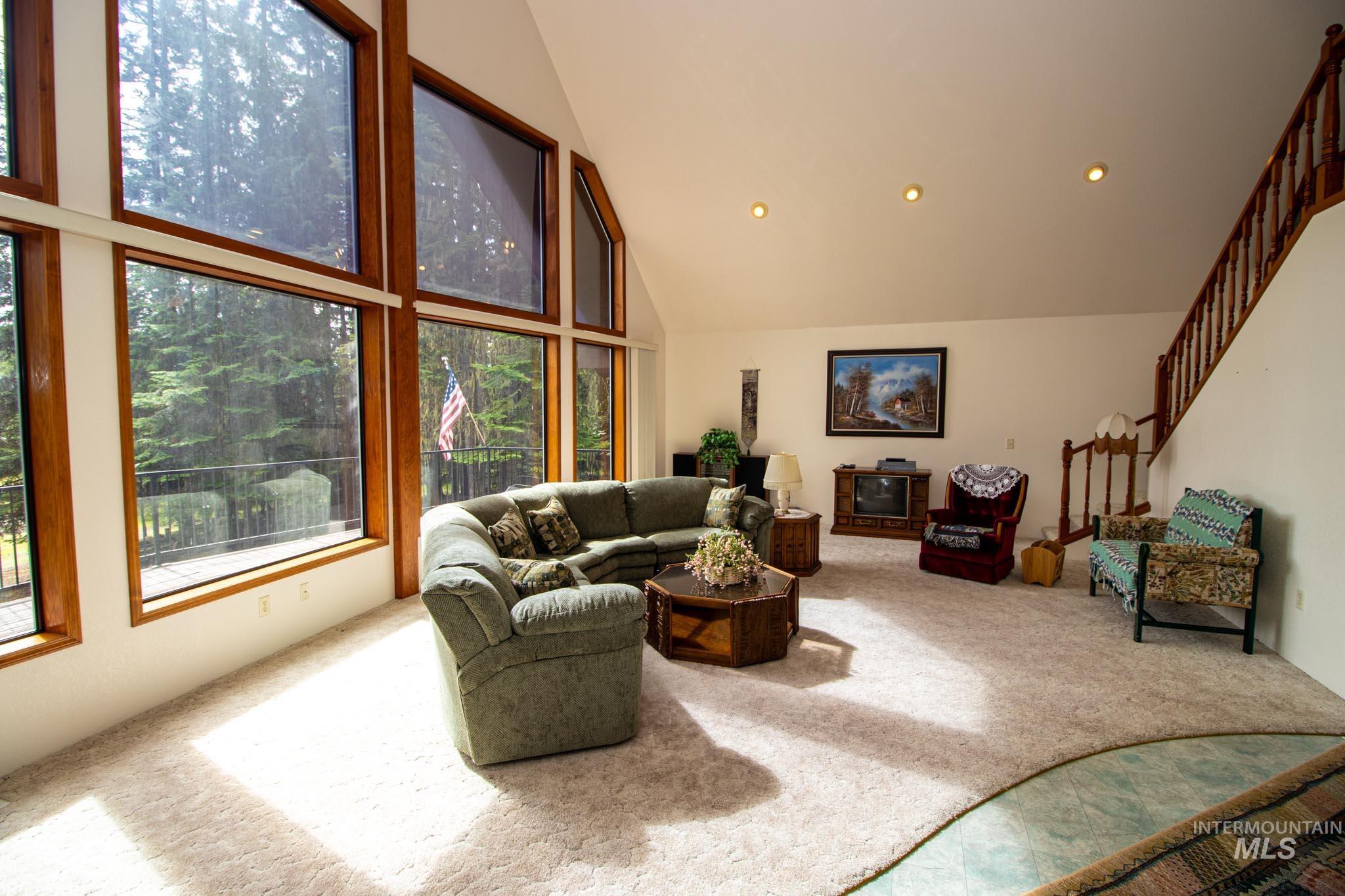 20888 Upper Fords Creek Road Weippe, ID 83553 - Photo 4 of 50 Carpeted living room featuring stairs and vaulted ceiling