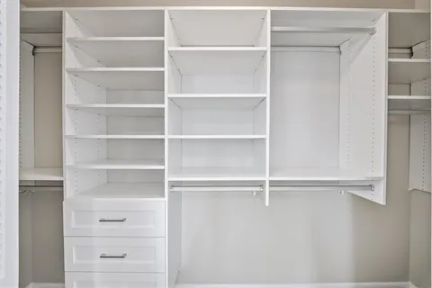 a view of walk in closet with empty racks