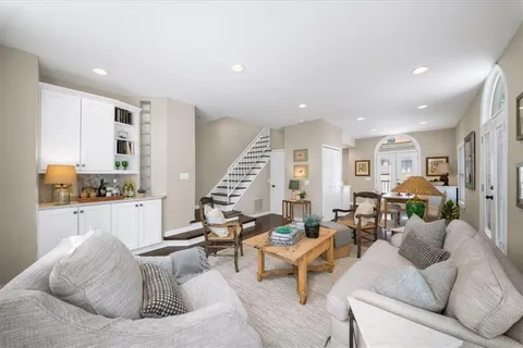 a living room with furniture kitchen view and a window