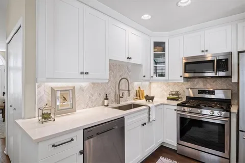 a kitchen with sink a microwave and cabinets