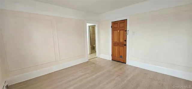 an empty room with wooden floor and closet area
