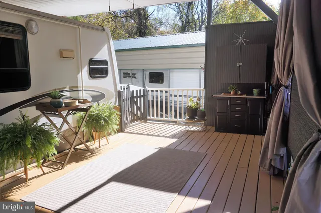 a view of a patio with table and chairs with wooden floor and fence