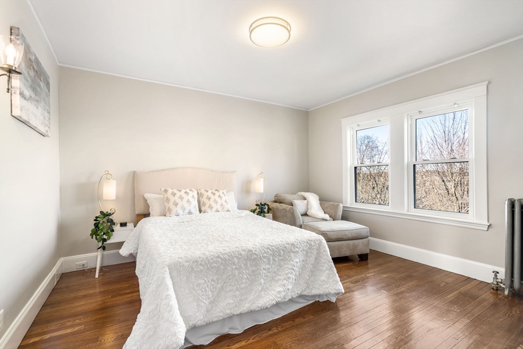 8 Charlesview Street, Unit 8 Boston, MA 02135 - Photo 9 of 12 a bedroom with a bed and wooden floor