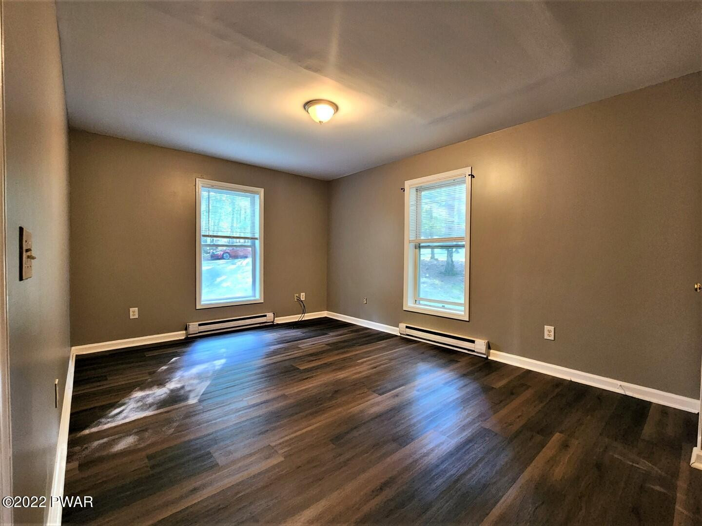 113 Butternut Road Milford, PA 18337 - Photo 6 of 15 an empty room with wooden floor and windows