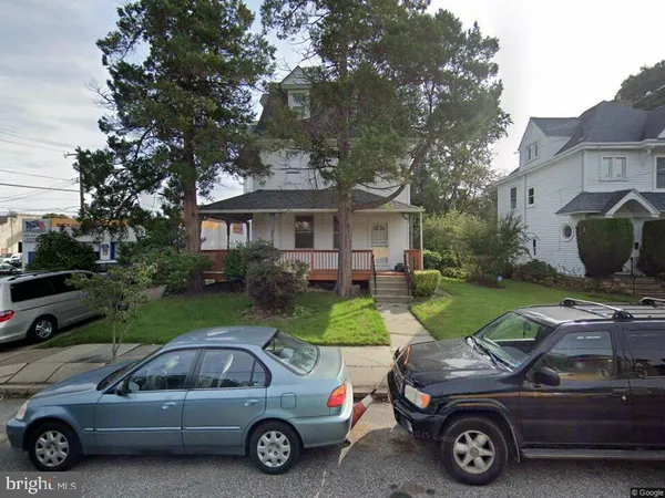 a car parked in front of a house with a yard
