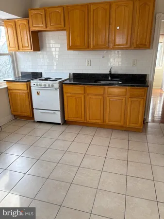 a kitchen with a sink a stove and cabinets