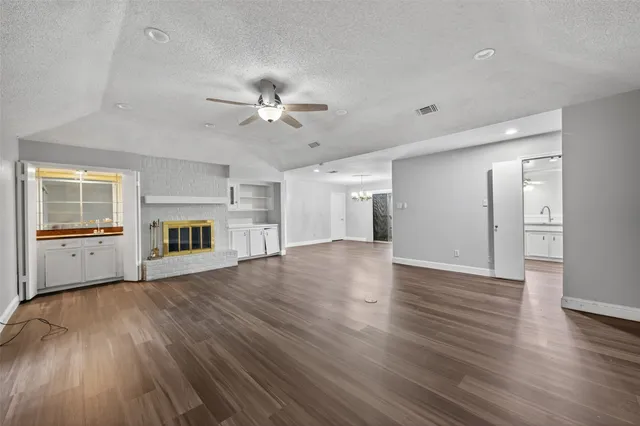 a view of an empty room with a fireplace and a window