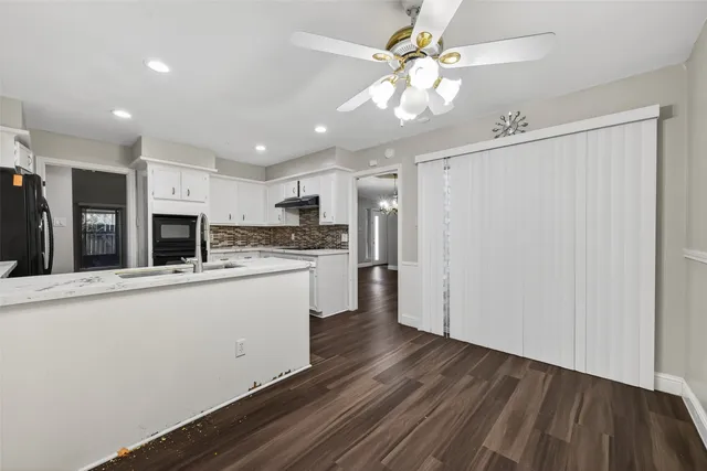 a open kitchen with a refrigerator a stove top oven a chimney and a counter space