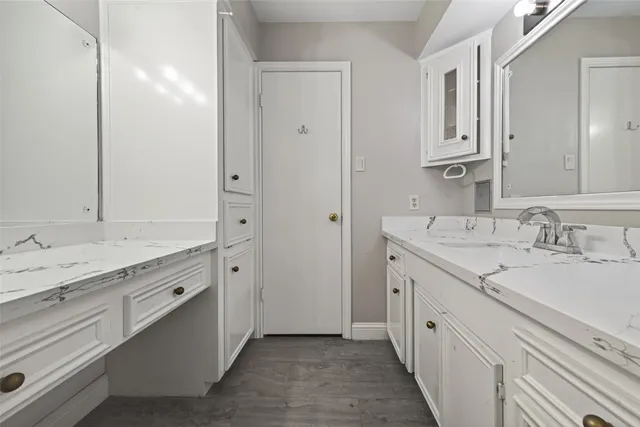 a spacious bathroom with a granite countertop sink double and mirror