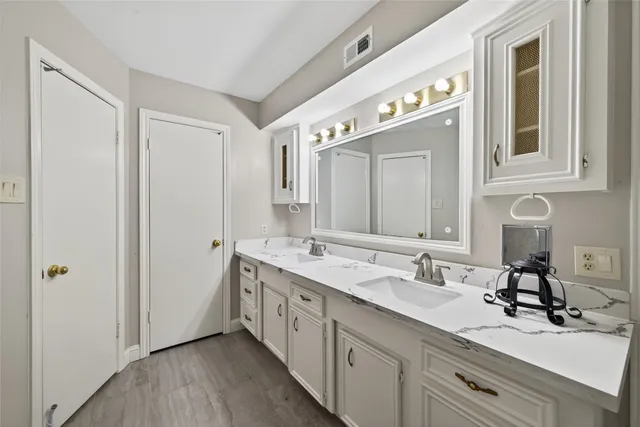 a spacious bathroom with a double vanity sink and a mirror