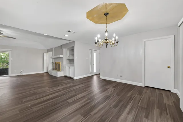 a view of an empty room with wooden floor and entryway