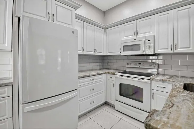 a kitchen with granite countertop a sink and chandelier