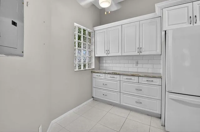 a kitchen with granite countertop a refrigerator sink and cabinets