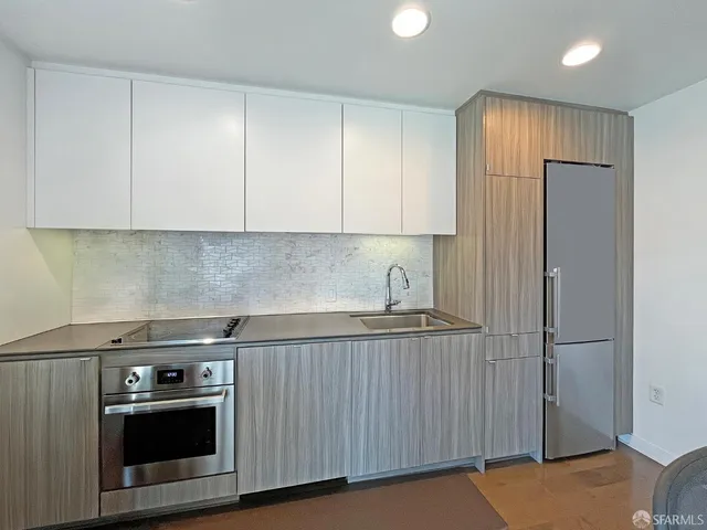 a kitchen with stainless steel appliances granite countertop a stove a sink and a refrigerator