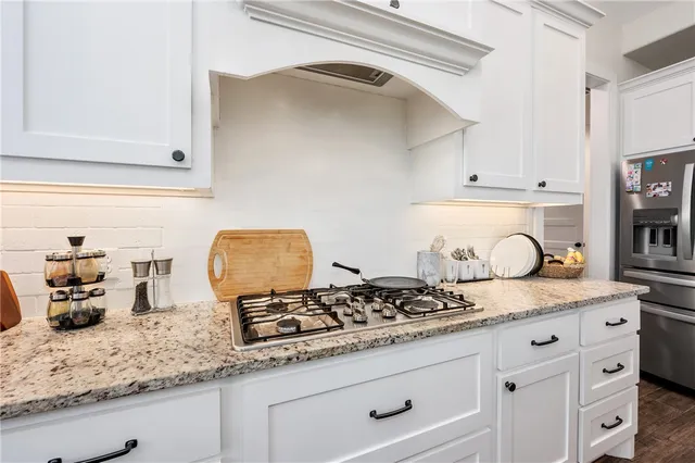 a kitchen with granite countertop white cabinets and white appliances