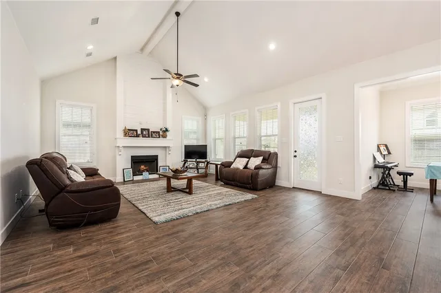 a living room with furniture a fireplace and a chandelier