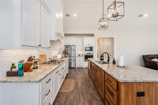 a kitchen with granite countertop lots of counter top space and stainless steel appliances